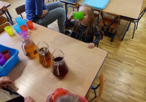 Dziewczynka degustuje różne smaki herbaty.