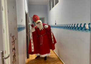 Święty Mikołaj idzie na spotkanie z dziećmi.