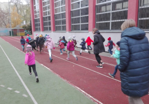 Dzieci wraz ze swoimi paniami biora udział w biegu z okazji Dnia Niepodległości.