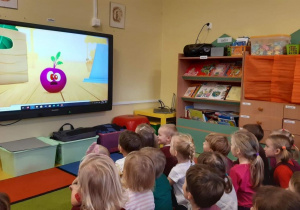 Dzieci oglądają prezentację multimedialną o buraku.