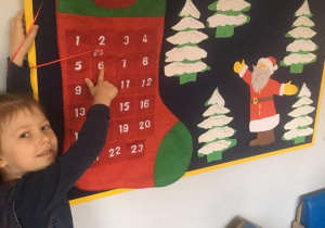 Dziewczynka wskazuje datę 6 grudnia w kalendarzu.