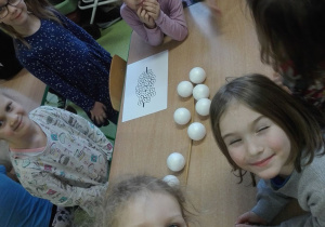 Warsztaty Szkatułka "płazy" - dzieci układają skrzek ze styropianowych jajek.