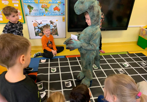Poprowadź Dinozaura do domu- dzieci wydają komendy: na przód, do tyłu, w prawo, w lewo i prowadzą Dinozaura do mety.