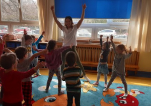 Warsztaty taneczne - dzieci rozciągają się przed poznaniem układu.