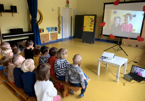 Dzieci oglądają filmik przygotowany przez Raczki z okazji Dnia Edukacji Narodowej.