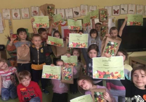 Dzieci chwalą się otrzymanymi dyplomami za konkurs warzywno owocowy.