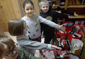 Dzieci pokazują ile prezentów zostało zebranych podczas akcji charytatywnej.