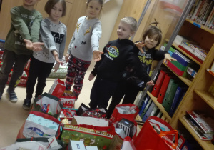 Dzieci pokazują ile prezentów zostało zebranych podczas akcji charytatywnej.