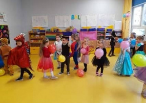 Dzieci bawią się balonami podczas tańców na balu karnawałowym.
