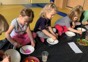 Dzieci malują miseczki.