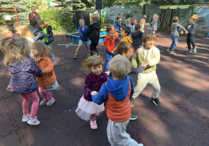 Dzieci tańczą na podwórku przedszkolnym.