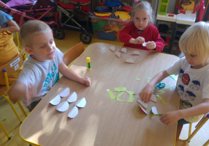 Dzieci sklejają arbuzy z wyciętych kółek.
