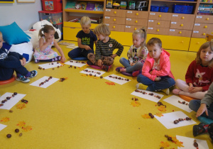 Zajęcia matematyczne, dzieci układają rytmy z darów jesieni.