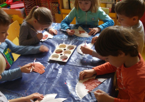 Dzieci maluję jeże z papierowych talerzyków.