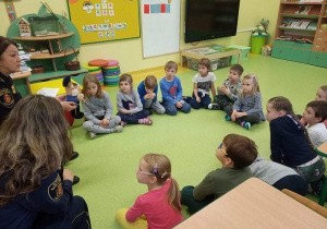 Dzieci słuchaja policjantki.
