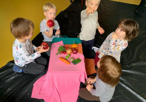 Dzieci ukłądają postacie z warzyw i owoców.