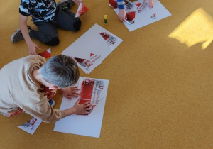 Dzieci układają flagę Polski z elementów.