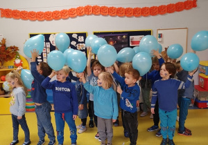 Dzień Praw Dziecka- dzieci ubrane na niebiesko machają niebieskimi balonami.