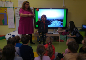 Warsztaty "Zanieczyszczenia"- dzieci obserwują model słońca i ziemi.