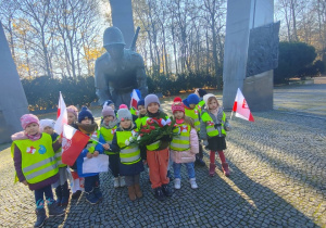 Dzieci pozują do zdjęcia przy pomniku Sapera.