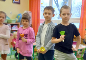 Dzieci stoją i każde trzyma w ręku kolorowy dzwonek. Nauka do występu dla babci i dziadka.