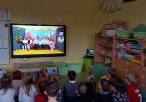 Dzieci oglądają na dużym ekranie swój nagrany występ dla babć i dziadków.