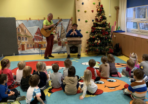 Dzieci słuchają dźwięków instrumentu.