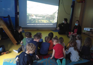 Dzieci oglądają zdjęcie pejzażu na ekranie.