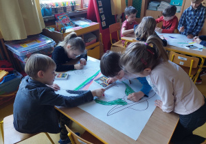 Dzieci kolorują portret Pani Wiosny w grupach.
