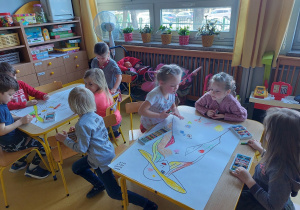 Dzieci kolorują portret Pani Wiosny w grupach.