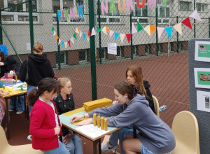 Dziewczynki wykonują doświadczenia przy stoliku na boisku szkolnym