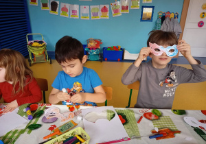 Dzieci ozdabiają maski walentynkowe.