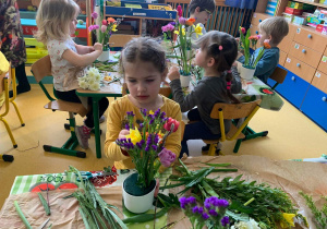 Dzieci tworzą kompozycje kwiatowe.