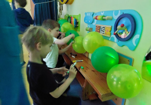 Dzień dziecka- dzieci malują twarze na balonach.