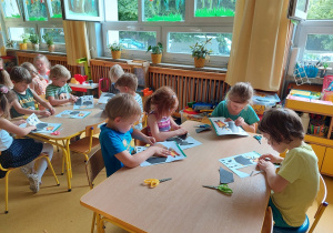 Dzieci wypychają i sklejają tukany z papieru.