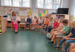 Dzieci w bibliotece szkolnej słuchają fragmentów wierszy.