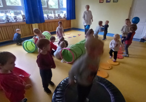 Dzieci bawią się w sali gimnastycznej.