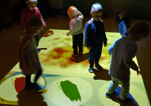 Dzieci bawią się na interaktywnym dywanie.