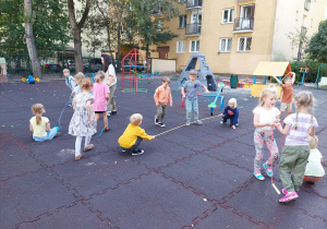 Dzieci uczą się skakać przez skakankę.