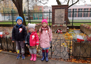 Dzieci stoją przed pomnikiem.