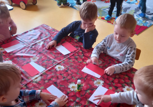 Dzieci wykonują biało - czerwoną chorągiewkę.