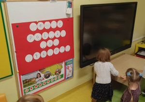 Dzieci wyszukują litery do rozwiązania rebusu.