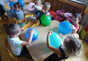 Dzieci ozdabiają balony z użyciem flamastrów.