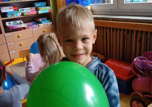 Chłopiec pokazuje ozdobiony przez siebie balon.