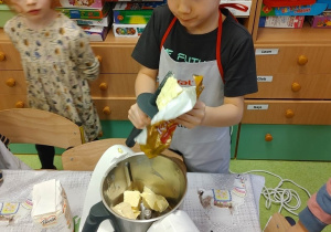 Pieczenie ciastek- chłopiec wrzuca masło do miksera.