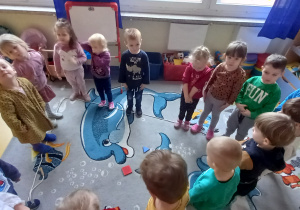 Dzieci stoją na linie ułożonej w kształt trójkąta.
