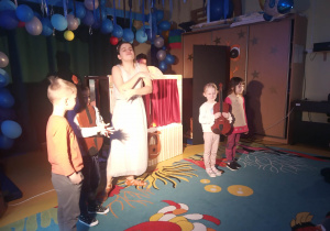 Dzieci stoją na scenie z instrumentami.