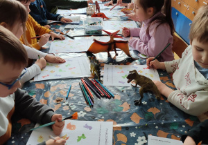 Dzieci rozwiązują zagadki związane z dniem dinozaura.