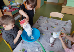Dzieci wsypują do miski składniki na masę solną.