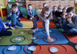 Dzieci grają w twistera z monetami.